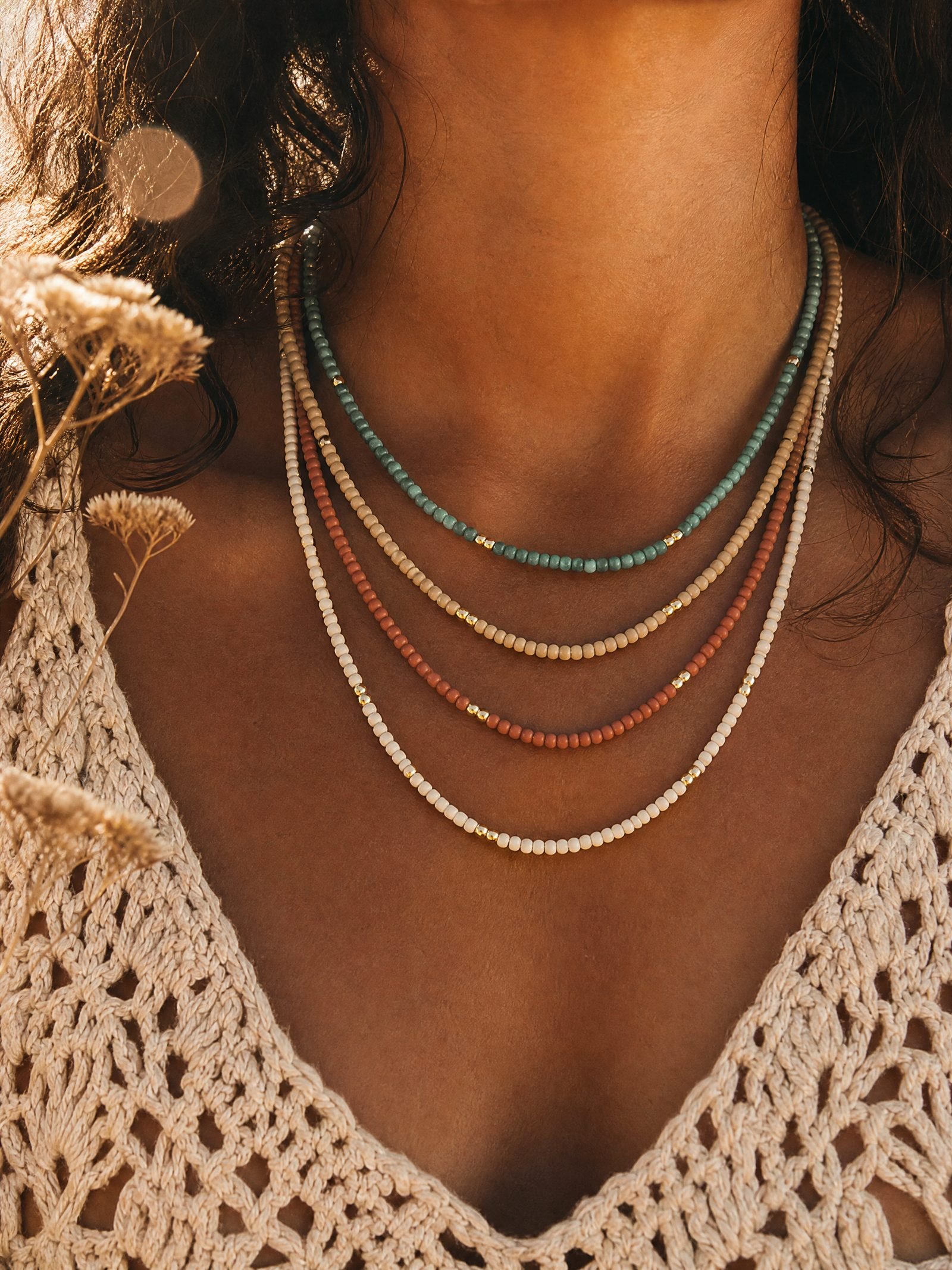 A stack of four beaded necklaces
